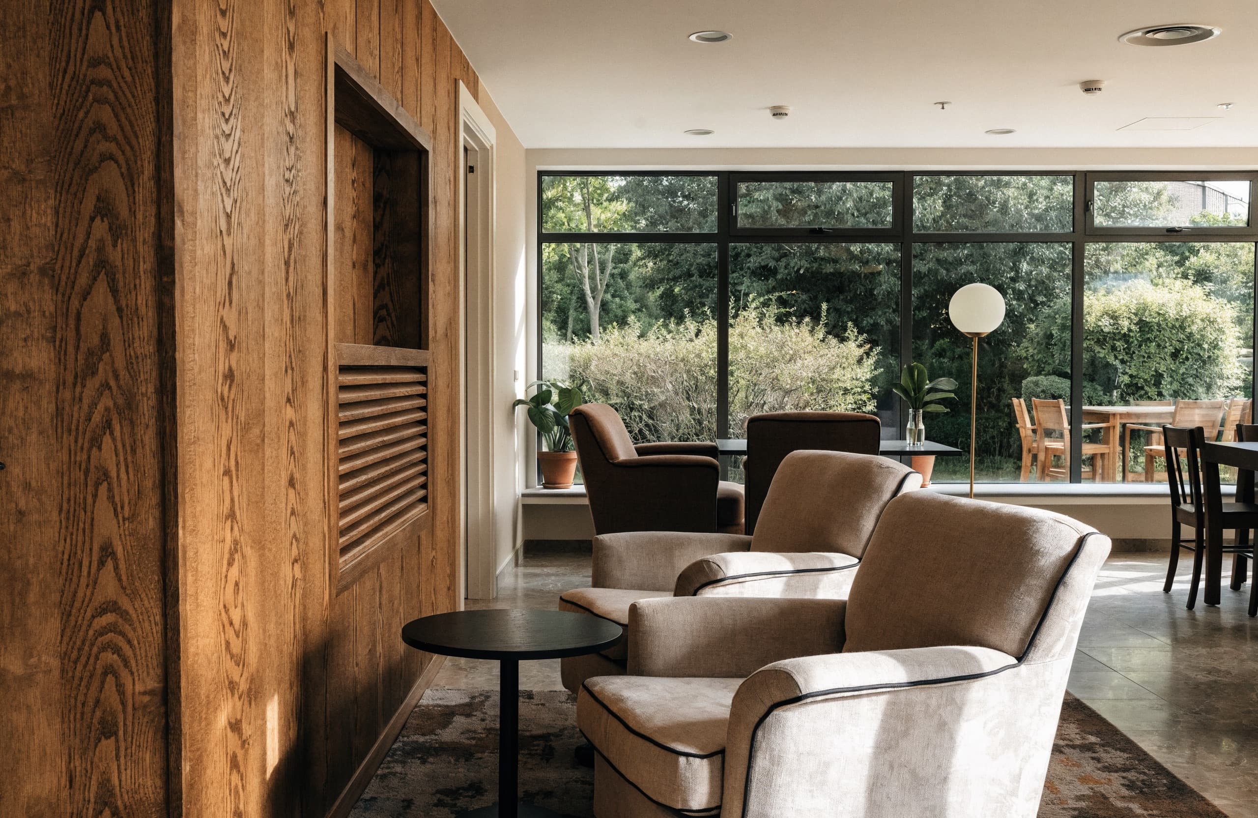 A warm communal lounge with garden views